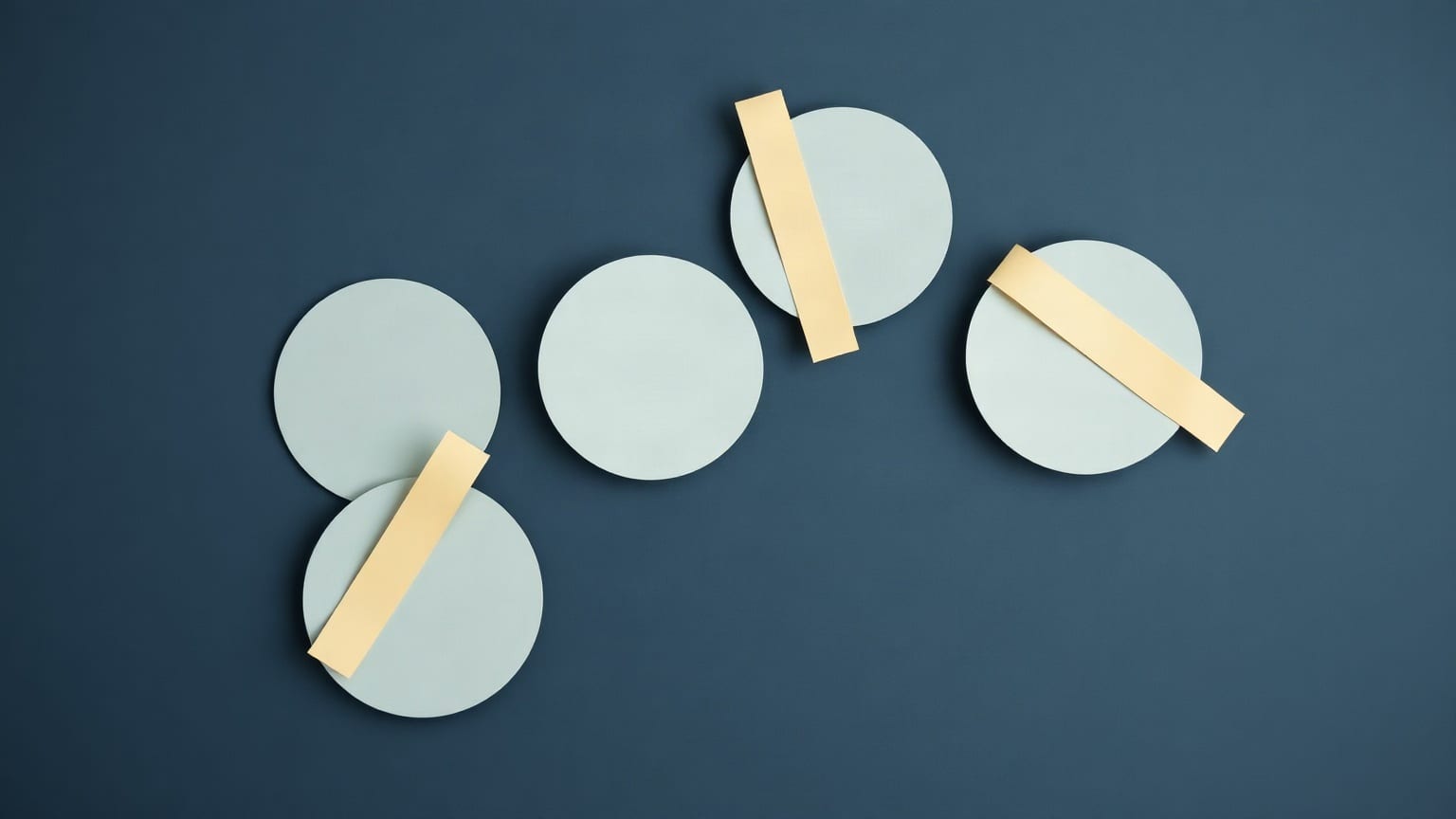 Five pale paper discs on a deep slate ground, three of them crossed by a cream paper strip and two left bare